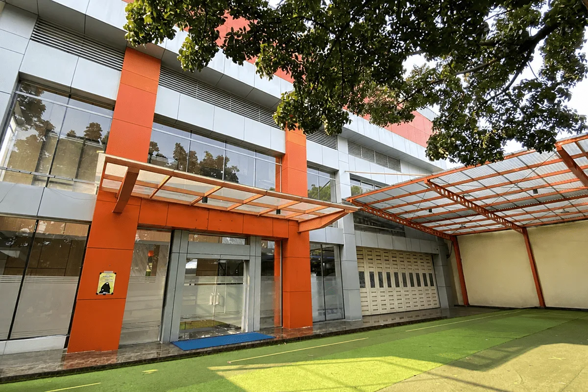 The Bojana Tirta Islamic School building, with orange pillars and a green courtyard